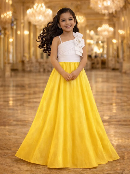 Young girl in a white top and yellow skirt standing in a grand hall with chandeliers.