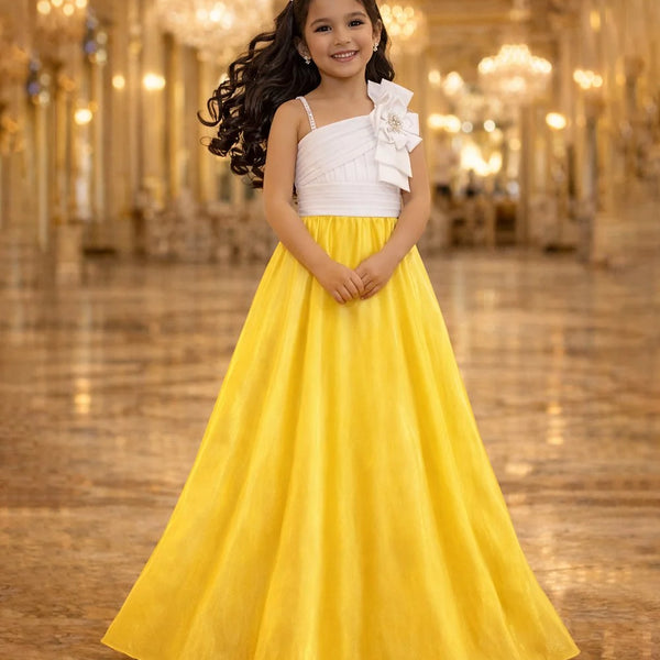 Young girl in a white top and yellow skirt standing in a grand hall with chandeliers.