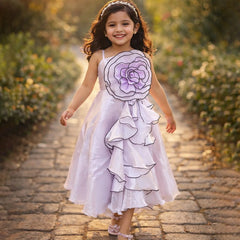 Young girl in a floral dress walking on a stone path with greenery around.