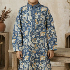 Child wearing a blue patterned kurta standing in a rustic setting.