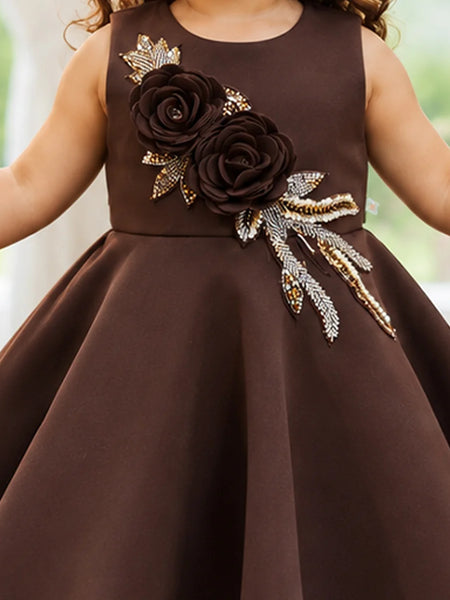 Close-up of girls' brown frock with gold leaf details
