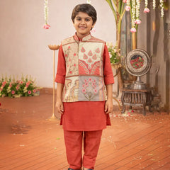 Child wearing a traditional outfit with a floral vest in a decorated indoor setting.