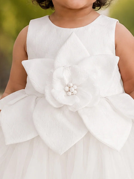 Close-up of baby girls' white frock layered flower