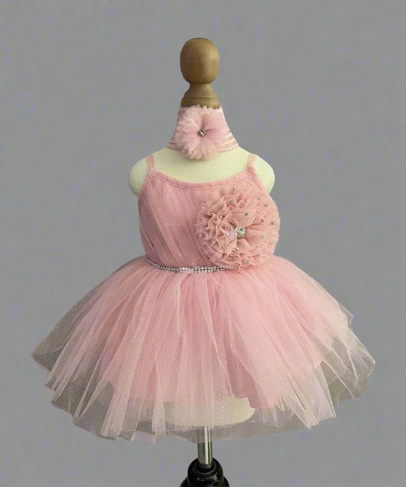  It’s a stylish peach Colored frock that comes with a back zip closure. It is paired up with matching shoes and hair band.
