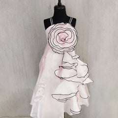 Mannequin wearing a white dress with floral design on a plain background