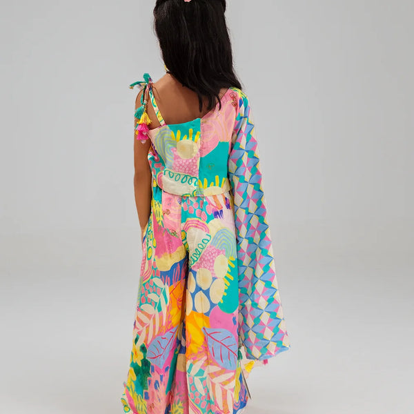 Girl wearing a colorful patterned dress on a plain background