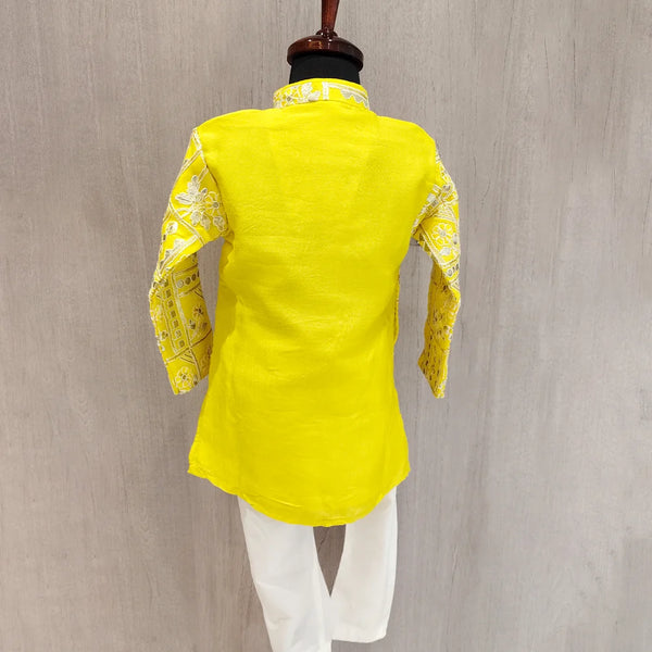 Yellow traditional outfit with white pants on a mannequin against a gray background