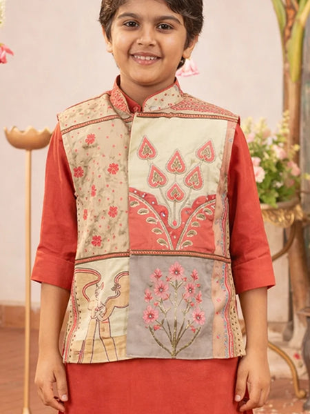 Child wearing a traditional embroidered vest over a red outfit with a decorative background.