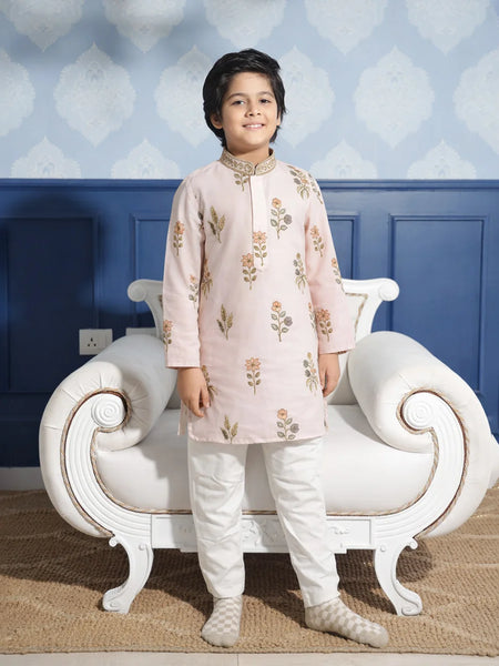 Child wearing a traditional outfit standing in front of a decorative chair with a blue wall background.