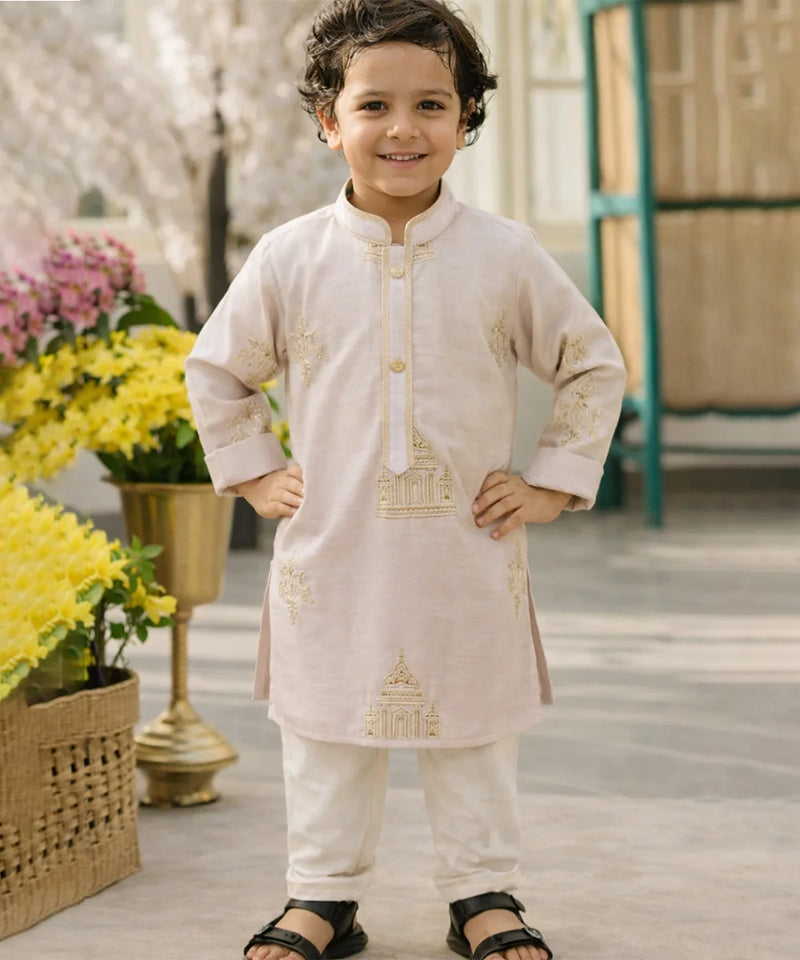 Child wearing a traditional outfit with floral decorations in the background