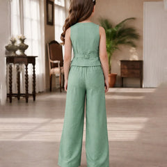 Woman wearing a green jumpsuit in a room with wooden floors and furniture.