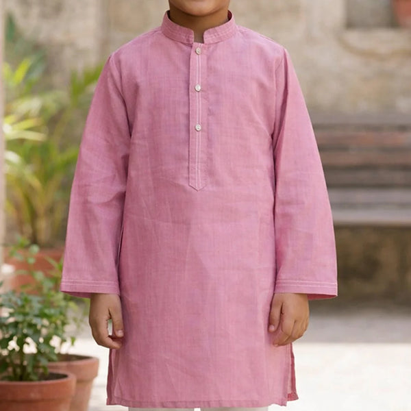 Child wearing a pink kurta with a blurred outdoor background