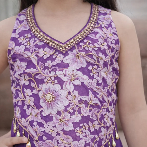 Purple floral embroidered top with gold details on a blurred background