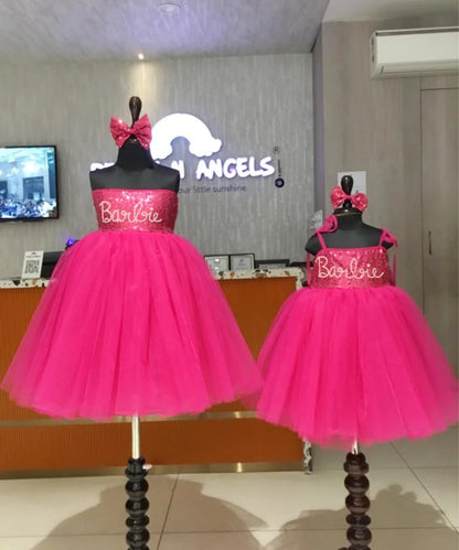 It’s a Pink Colored Barbie frock that comes with a back hook closure and is perfect birthday wear for girls. It features a Barbie Inscription on the dress and an attached belt to be tied at the back curated from net fabric.