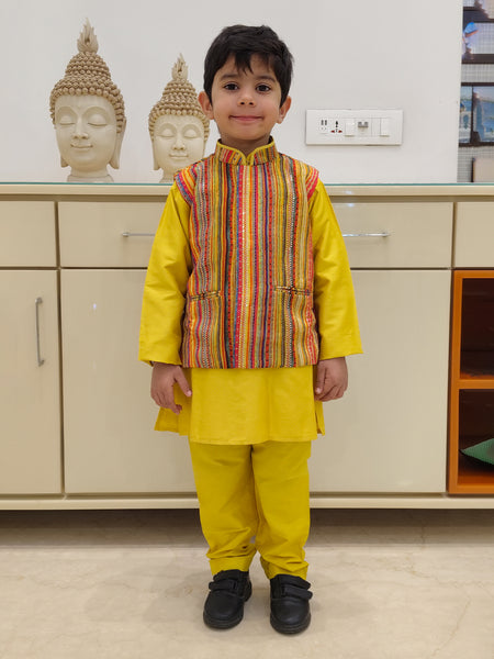 It is a yellow color plain kurta pajama with a multi striped jacket