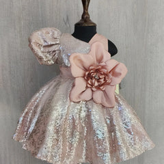 Sparkly dress with a large pink flower on a mannequin against a gray background