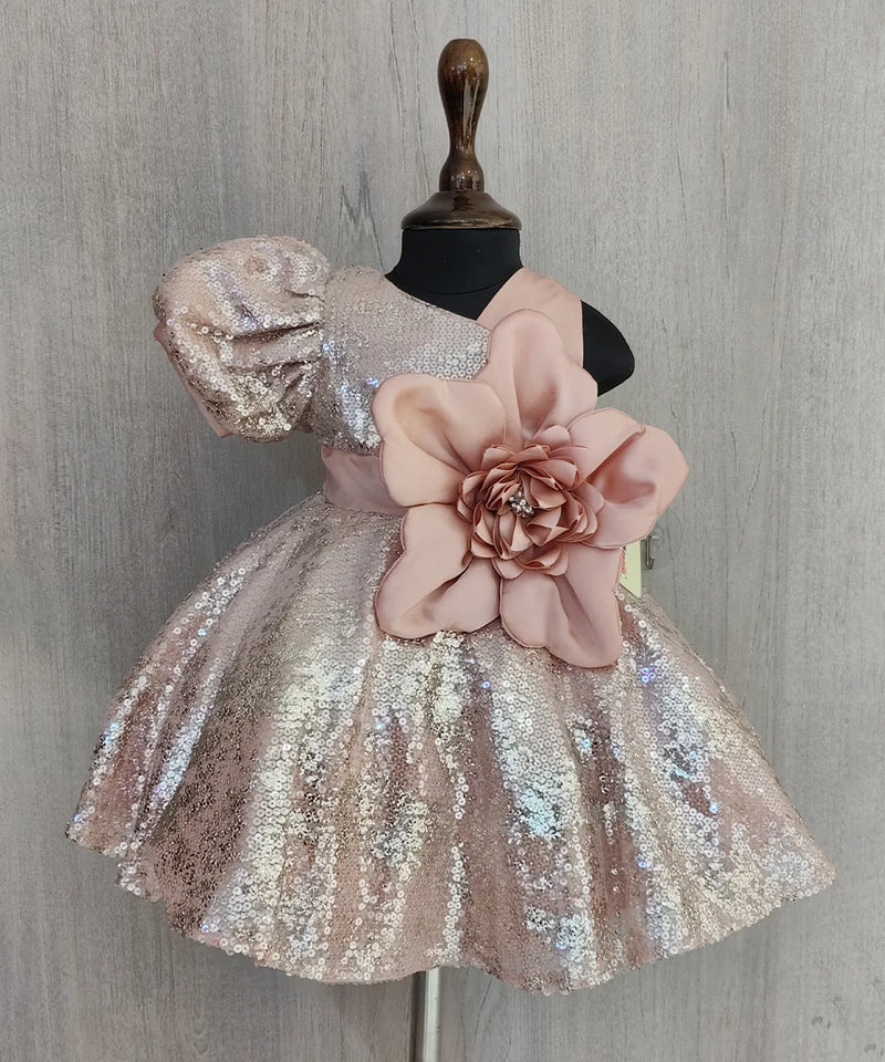 Sparkly dress with a large pink flower on a mannequin against a gray background