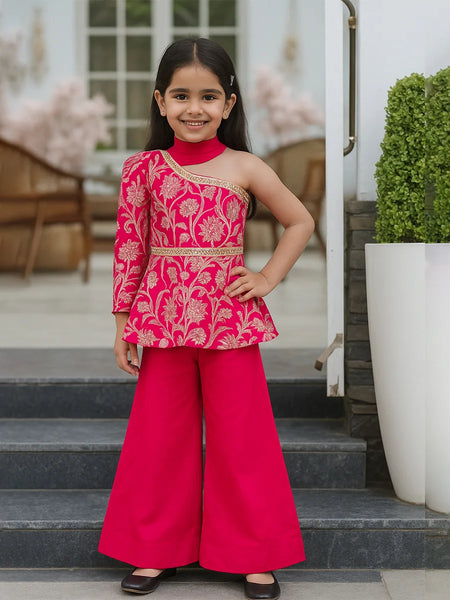 Young girl in a pink traditional outfit standing on steps outdoors.