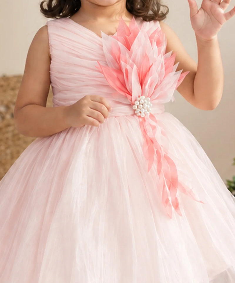 Close-up of pink 3D flower with pearl centre on baby girl frock