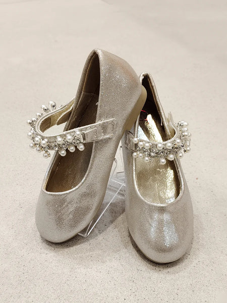 Pair of silver glittery shoes with decorative straps on a light background