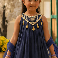 Young girl wearing a blue traditional outfit with gold details outdoors.