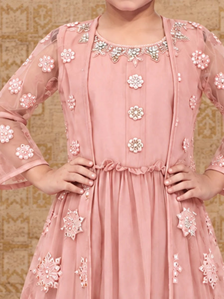 A pink traditional Indian dress with intricate floral embroidery and beadwork, shown on a model against a patterned beige background.