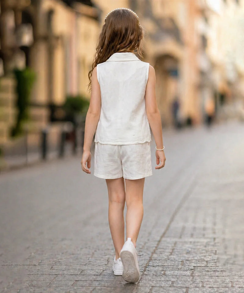 Young girl in a white outfit walking down a street with a blurred background