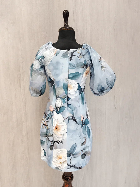 Floral dress on a mannequin against a beige wall