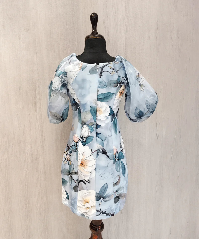 Floral dress on a mannequin against a beige wall