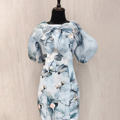 Light blue floral dress on a mannequin against a beige background