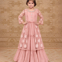 A pink traditional Indian dress with intricate floral embroidery and beadwork, shown on a model against a patterned beige background.