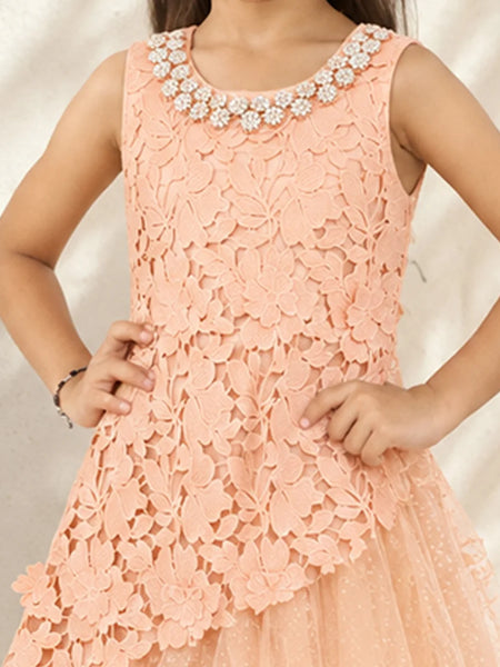 A sleeveless peach lace dress with a floral pattern, featuring a beaded embellished neckline and a layered tulle skirt, shown on a child model.