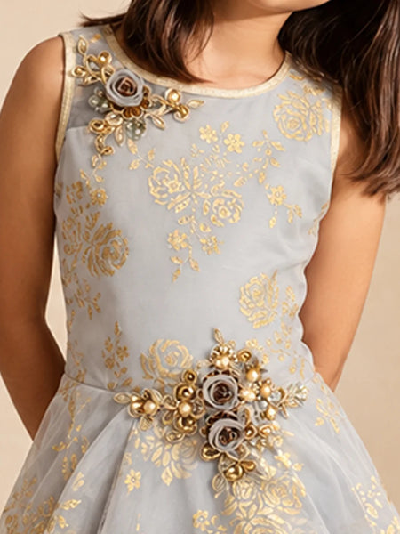 A sleeveless light gray dress with gold floral embroidery and decorative gray and gold floral embellishments on the bodice and waist, shown on a child model against a plain beige background.