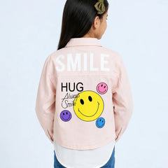 A child model shown from the back wearing a light pink denim-style jacket with a large graphic on the back. The graphic features the word 'SMILE' in white, 'HUG Always Smile' in black script and block lettering, a large yellow smiley face, and smaller pink, purple, and blue smiley faces.