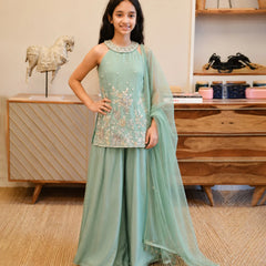 Girl wearing a sea green embroidered sharara set with dupatta.