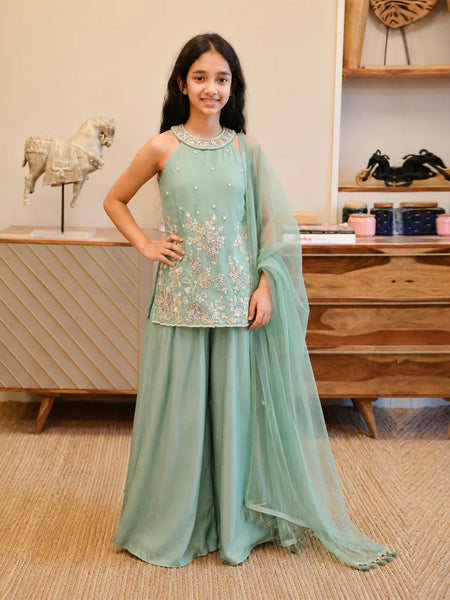 Girl wearing a sea green embroidered sharara set with dupatta.
