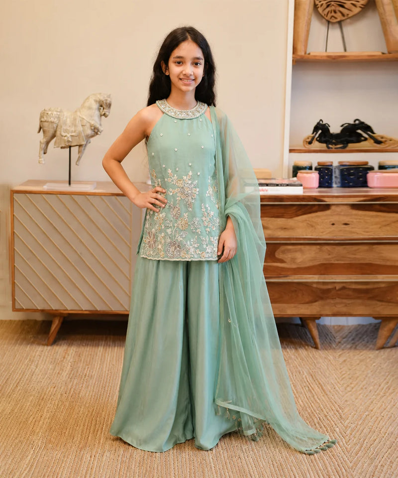 Girl wearing a sea green embroidered sharara set with dupatta.