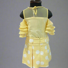 Yellow polka dot dress on a mannequin against a plain background