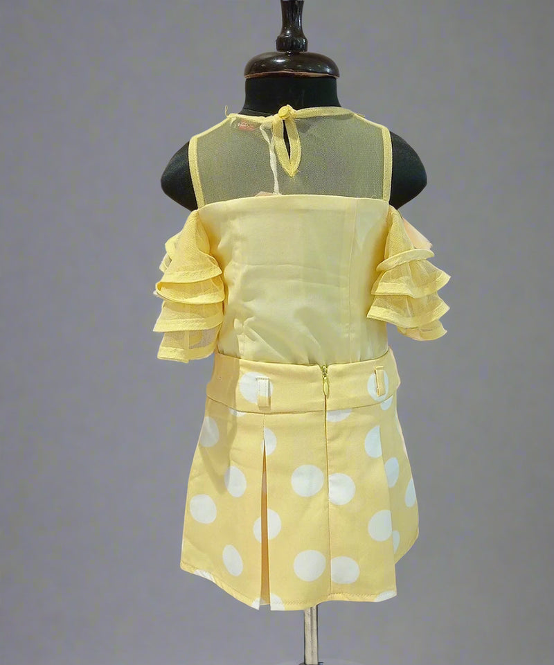 Yellow polka dot dress on a mannequin against a plain background