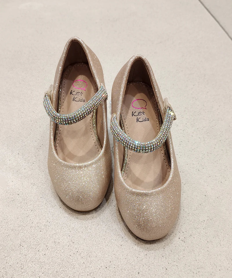 Pair of glittery shoes with rhinestone straps on a light background