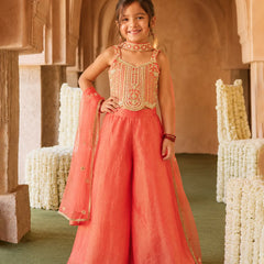 Girl wearing an orange embroidered sharara set with dupatta.