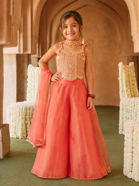 Girl wearing an orange embroidered sharara set with dupatta.