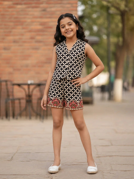 Young girl wearing a patterned dress standing on a sidewalk with a blurred background