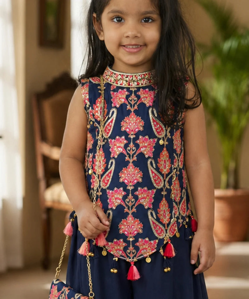 Young girl wearing a traditional embroidered top with pink floral patterns and red tassels.