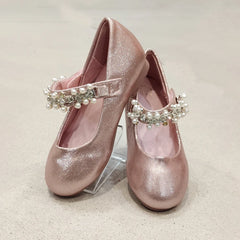 Pair of pink glittery shoes with pearl embellishments on a light background