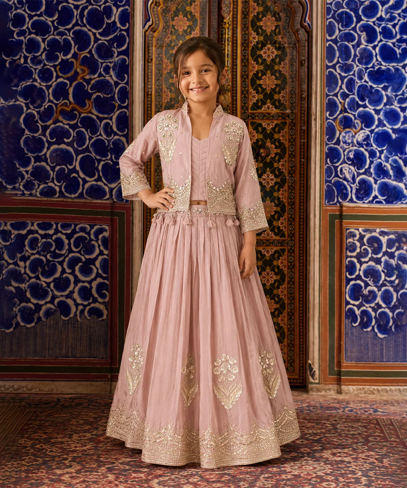 Girl wearing a pink embroidered lehenga with jacket.
