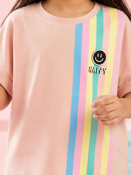 A child wearing a light pink short-sleeve t-shirt with vertical pastel stripes in blue, pink, yellow, and mint green on the right side. A black circular smiley face graphic with the word 'HAPPY' is printed on the chest.