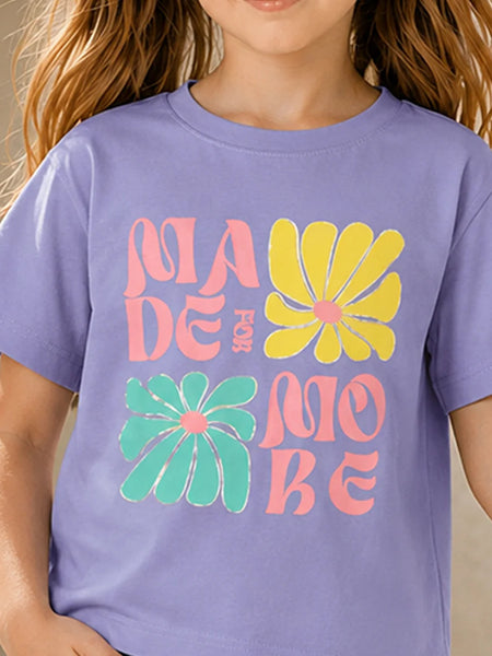 A child wearing a lavender purple t-shirt with a retro-style graphic that reads 'MADE FOR MOBE' in pink and yellow text, accented by two large yellow and green flowers on the front.
