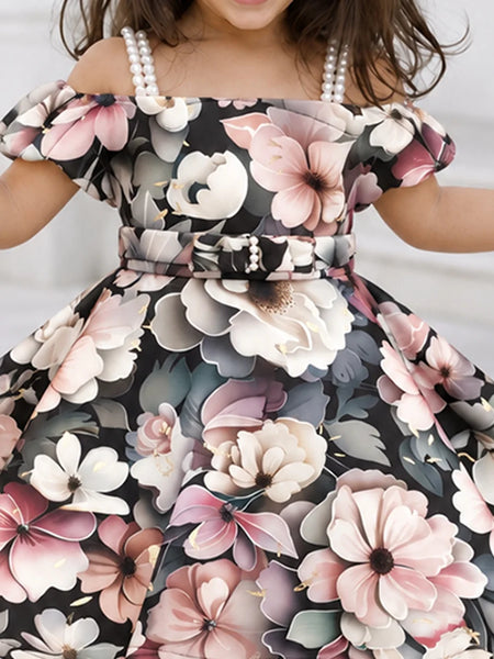 Close-up of girls' black floral frock with belt