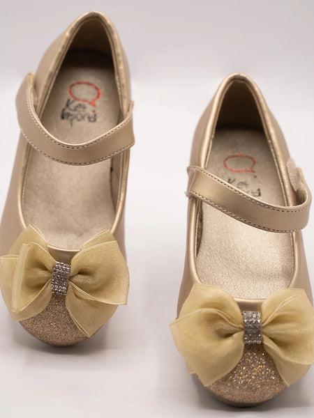 Close-up of girls' gold ballerina shoes with sparkling toe and bow accent, perfect for festive occasions in Jaipur